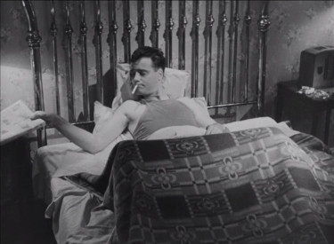 A man smoking in bed.