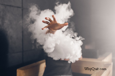 E-cigarette user extending her hand through a cloud of vapor.