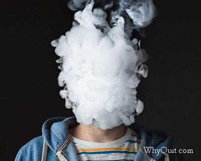 E-cigarette user with his face clouded in vape.