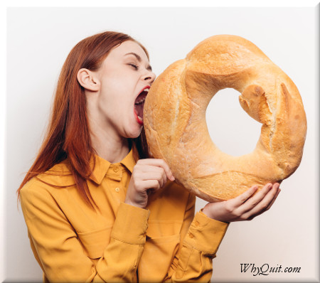 Woman trying to eat a giant bagel