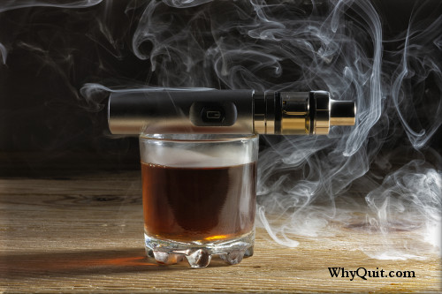 Picture of a glass of alcohol with an ecig tank on top.