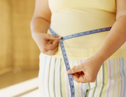 A woman in pjs with a tape measure around her waist.