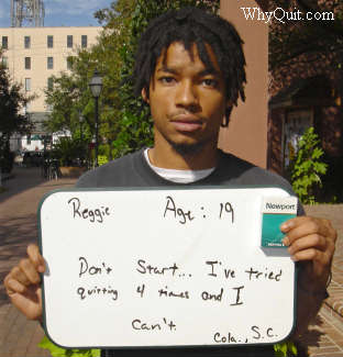 Reggie, a 19 year-old Newport smoker holding a sign saying that he tried quitting four times and can't.