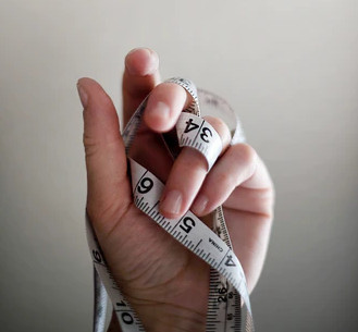 A hand holding a tape measure.
