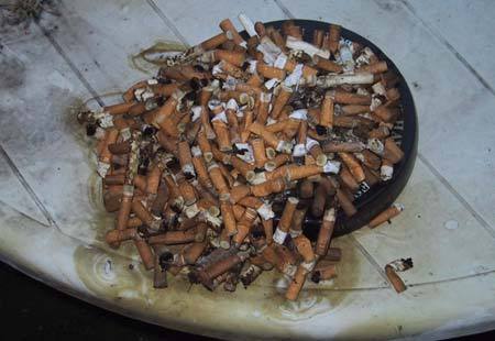 Cigarette butts filling ashtray