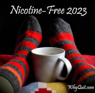 
Propped up and relaxing red and gray stripped winter stocking feet with a coffee cup between them captioned 'Nicotine-free 2023'