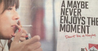A Philip Morris cigarette advertisement which states 'A Maybe never enjoys the moment. Don't be a maybe. Be Marlboro.' 
It shows the hands and face of a female lighting a cigarette.