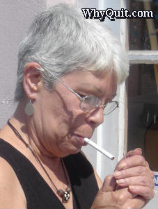 An older woman lighting a cigarette