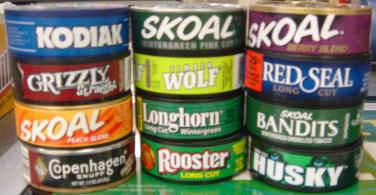 Picture of cans of smokeless tobacco including Kodiak, Grizzly straight, Skoal peach blend and fine cut, Wolf, Longhorn wintergreen, Red Seal long cut, Skoal Bandits, Copenhagen snuff, Rooster long cut, and Husky.