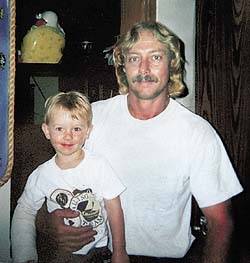 A healthy looking Bryan Lee Curtis holding his two-year-old son two months before his death